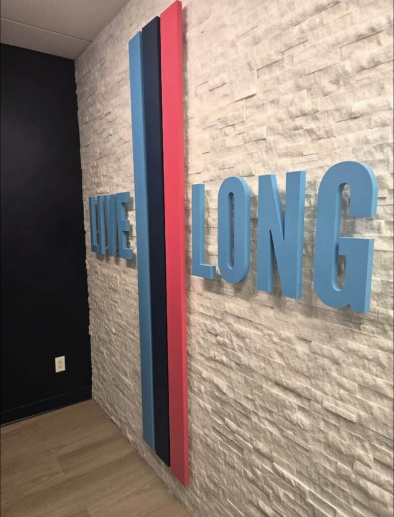Live Long custom dimensional sign installed for StretchLab. Interior branded signage designed to create a professional and welcoming wellness space.